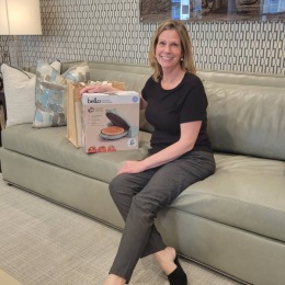 woman on a couch holding a waffle maker