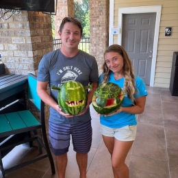 a couple holding carved watermelons